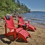 Two C01 Classic Adirondacks in Red with Footstools on a Muskoka beach