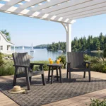 Two C41 Chat Chairs in new 28-Granite with a T02 Round Side Table on a deck, under a pergola lakeside